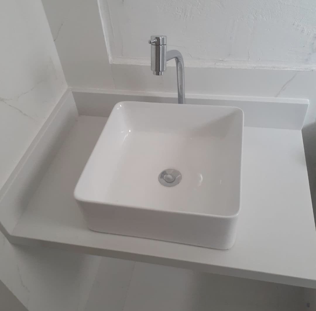 Bancada de lavabo em porcelanato branco com cuba de apoio