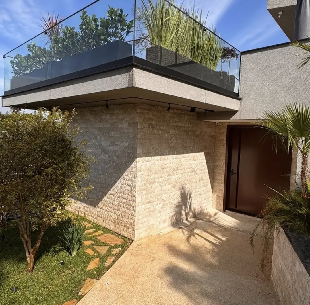 Fachada residencial com revestimento em pedra natural executado pela SC Acabamentos